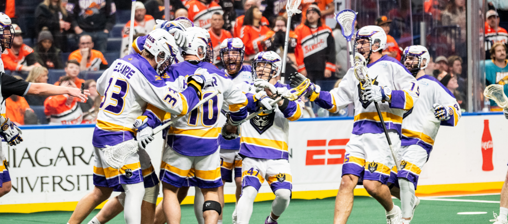 Roughnecks lacrosse team celebrating in a huddle